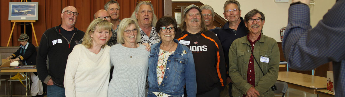 men and women posing for class reunion photo