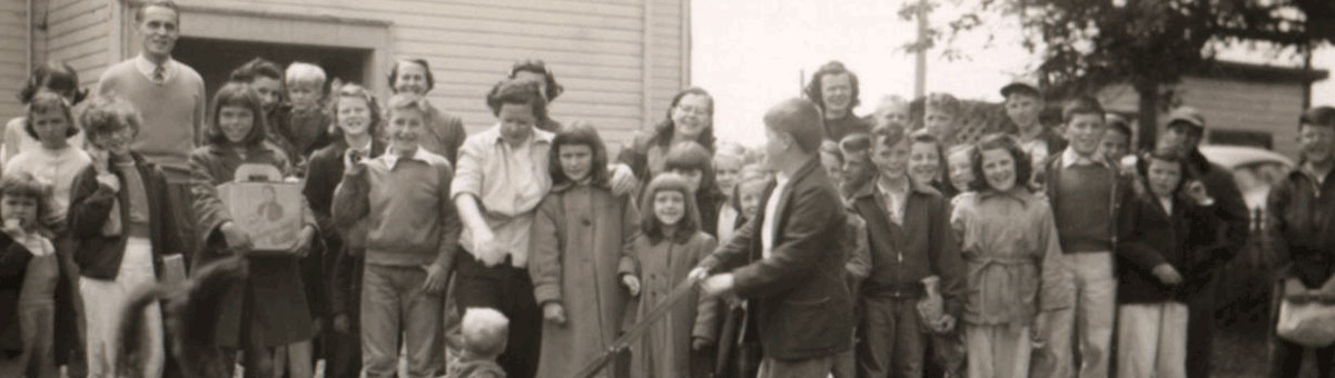 numerous males, females and children in family photo.