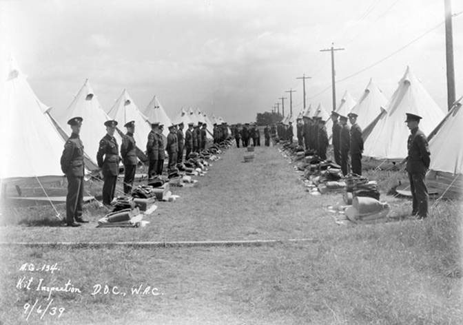 2 rows of soldiers of No.111(CAC) RCAF Squadron, standing during kit inspection on Sea Island
