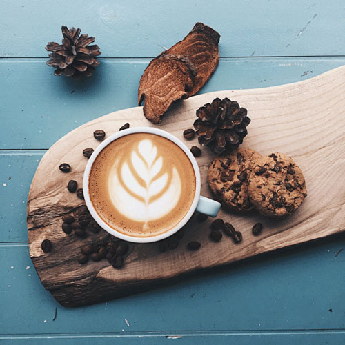 cup of coffee on wooden board with cookies
